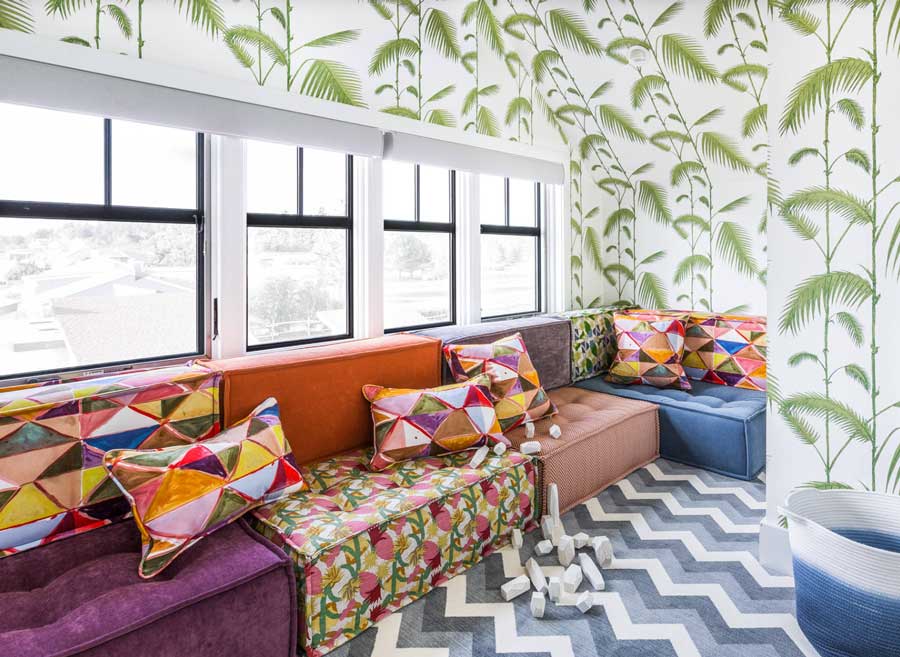 colorful interiors in a child's playroom with handmade cushions and vining wallpaper