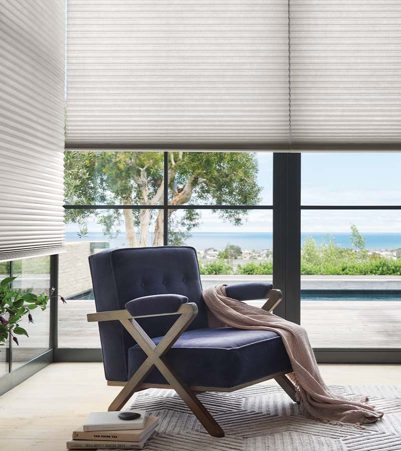 duette honeycomb shades with a reading nook comfortable chair