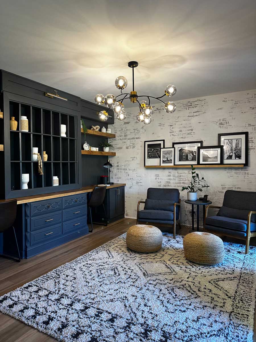 blue gray built-in shelving with wooden desk areas in den